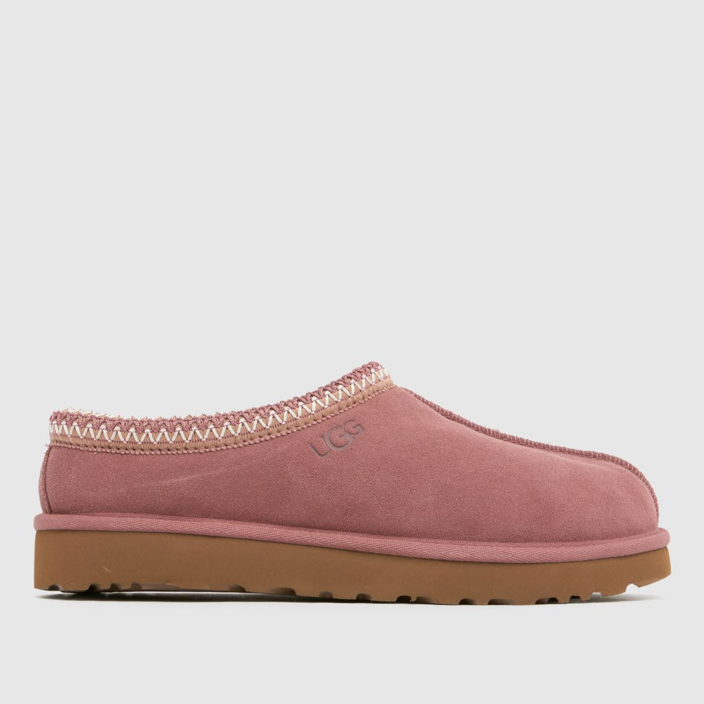 Pink UGG slipper with brown sole on a light gray background